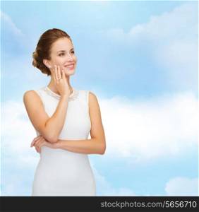 holidays, celebration, wedding and people concept - smiling woman in white dress wearing diamond ring over blue cloudy sky background