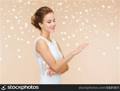 holidays, celebration, wedding and people concept - smiling woman in white dress wearing diamond ring over beige background and snow
