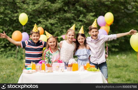 holidays, childhood and celebration concept - happy kids hugging on birthday party at summer garden. happy kids on birthday party at summer garden. happy kids on birthday party at summer garden