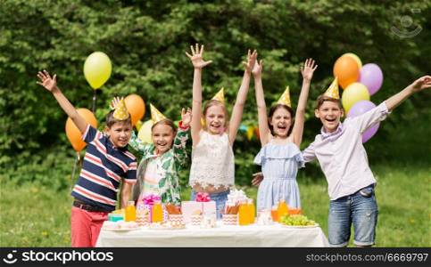 holidays, childhood and celebration concept - happy kids hugging on birthday party at summer garden. happy kids on birthday party at summer garden. happy kids on birthday party at summer garden