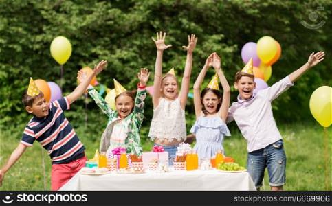 holidays, childhood and celebration concept - happy kids hugging on birthday party at summer garden. happy kids on birthday party at summer garden. happy kids on birthday party at summer garden