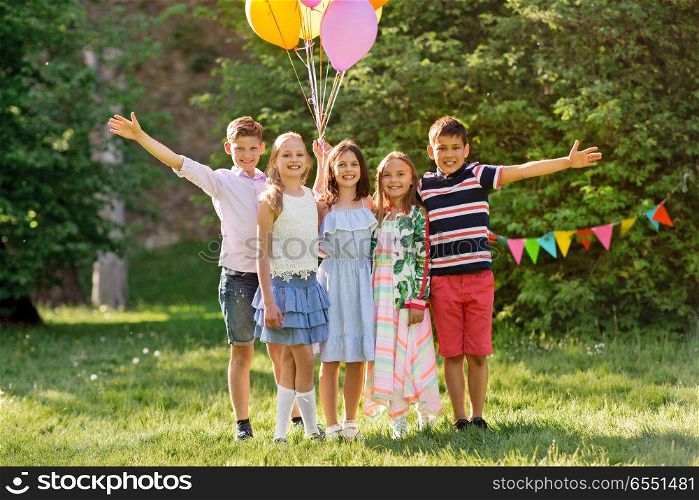 holidays, childhood and celebration concept - happy kids with balloons on birthday party at summer park. happy kids with balloons at summer birthday party. happy kids with balloons at summer birthday party