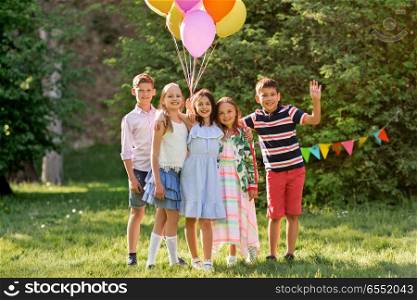 holidays, childhood and celebration concept - happy kids with balloons on birthday party at summer park. happy kids with balloons at summer birthday party. happy kids with balloons at summer birthday party