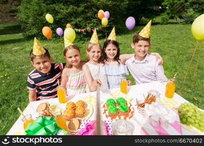 holidays, childhood and technology concept - happy kids taking picture by selfie stick on birthday party at summer garden. happy kids taking selfie on birthday party. happy kids taking selfie on birthday party