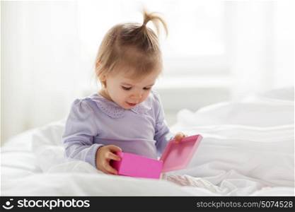 holidays, childhood, people and birthday concept - happy little baby girl with gift box at home. happy little baby girl with gift box at home