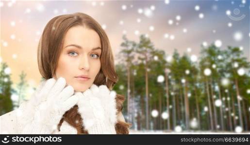 holidays, christmas and people concept - close up of beautiful woman over winter forest and snow background. close up of beautiful woman over winter forest