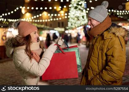 holidays, christmas and people concept - happy couple at with shopping bags in winter. happy couple at with shopping bags in winter