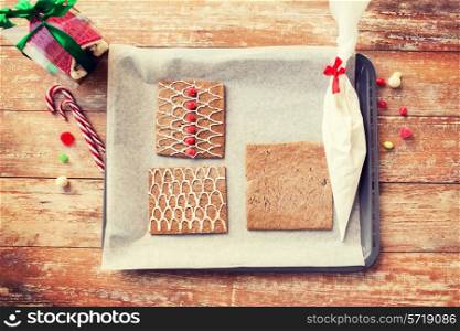 holidays, christmas, baking and sweets concept - closeup of gingerbread house details on pan