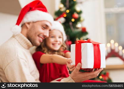 holidays, christmas, family and happiness concept - close up of father and daughter with gift box