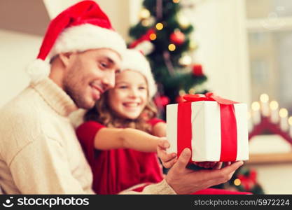 holidays, christmas, family and happiness concept - close up of father and daughter with gift box