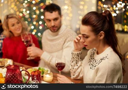 holidays, communication and celebration concept - young woman calling on smartphone and having christmas dinner with friends at home. woman calling on smartphone at christmas dinner