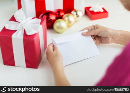 holidays, communication and people concept - close up of woman with letter and presents