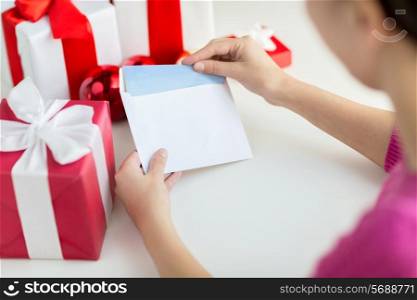 holidays, communication and people concept - close up of woman with letter and presents