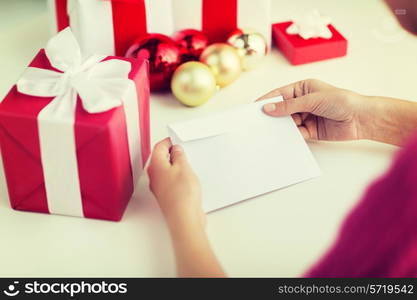 holidays, communication and people concept - close up of woman with letter and presents