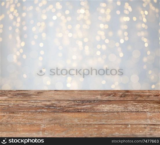 holidays concept - empty wooden surface or table with christmas golden lights background. empty wooden table with christmas golden lights