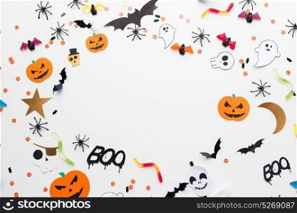 holidays, decoration and party concept - halloween paper decorations and sweets with blank copy space over white background. halloween party paper decorations and sweets