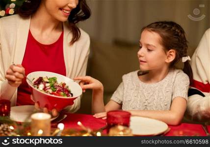 holidays, family and celebration concept - close up of happy mother and little daughter having christmas dinner at home. happy family having christmas dinner at home