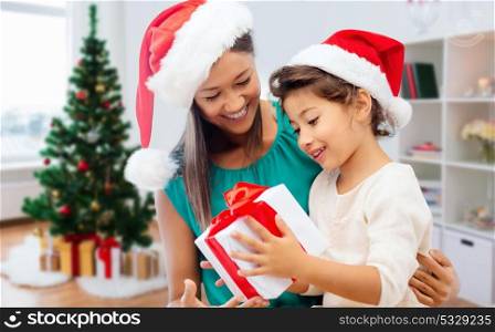 holidays, family and people concept - happy mother and daughter with christmas gift. happy mother and daughter with christmas gift