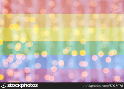 holidays, gay pride, homosexuality and tolerance concept - blurred golden lights over rainbow flag background
