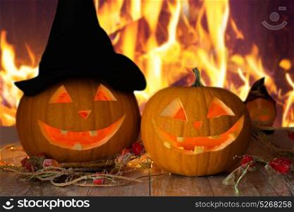 holidays, halloween and decoration concept - carved pumpkins on table over fire background. carved halloween pumpkins on table over fire
