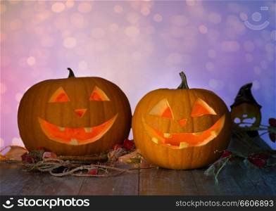 holidays, halloween and decoration concept - close up of carved pumpkins on table over lights background. close up of halloween pumpkins on table