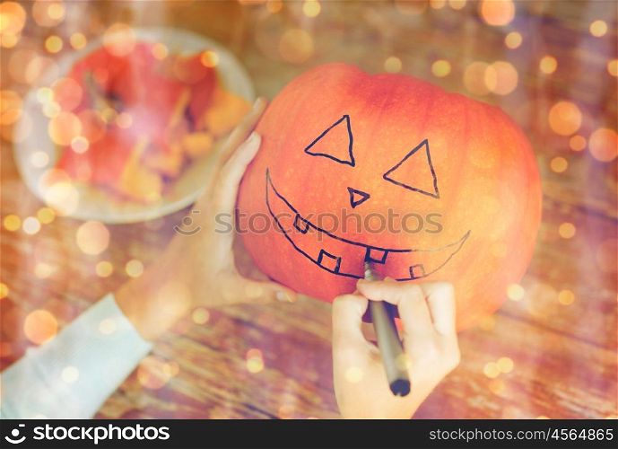 holidays, halloween, decoration and people concept - close up of woman with pumpkins at home