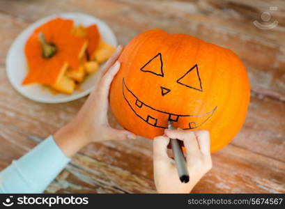 holidays, halloween, decoration and people concept - close up of woman with pumpkins at home