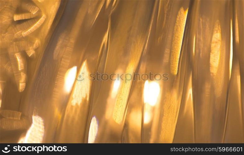 holidays, illumination and decoration concept - lights reflection on glass or golden metallic background