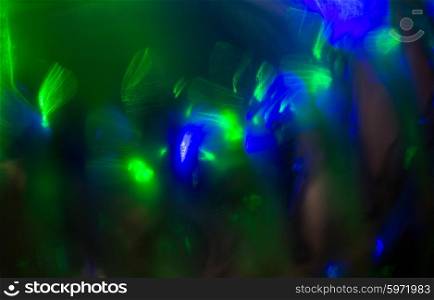 holidays, illumination and electricity concept - blue green night lights bokeh over dark background