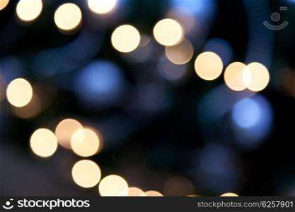 holidays, illumination and electricity concept - colorful bright lights on dark blue night background
