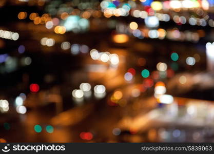 holidays, illumination and electricity concept - colorful bright lights on dark night background