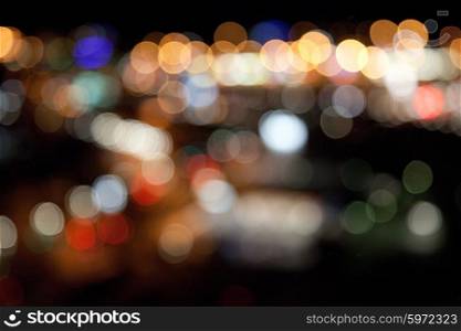 holidays, illumination and electricity concept - colorful bright lights on dark night background