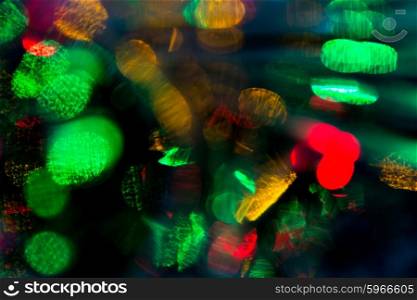 holidays, illumination and electricity concept - colorful bright night lights bokeh over dark background