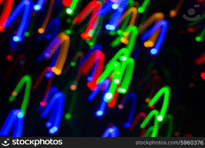 holidays, illumination and electricity concept - colorful bright night lights over black background