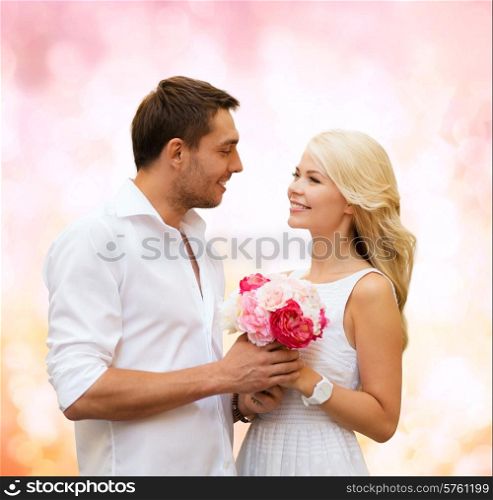 holidays, love, people and dating concept - happy couple with bunch of flowers over pink lights background