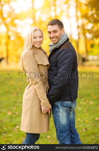 holidays, love, travel, tourism, relationship and dating concept - romantic couple in the autumn park