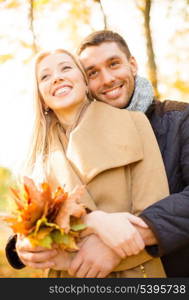 holidays, love, travel, tourism, relationship and dating concept - romantic couple in the autumn park