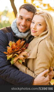 holidays, love, travel, tourism, relationship and dating concept - romantic couple in the autumn park