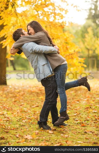 holidays, love, travel, tourism, relationship and dating concept - romantic couple playing in the autumn park