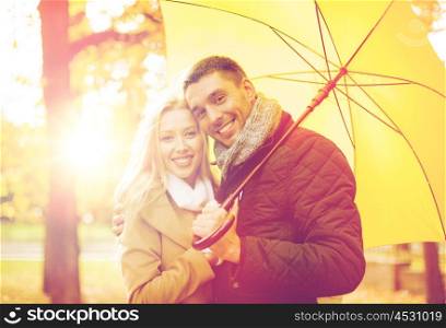 holidays, love, travel, tourism, relationship and dating concept - romantic couple with umbrella in the autumn park