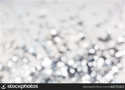 holidays, luxury and background concept - blurred silver christmas lights bokeh