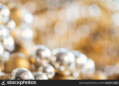 holidays, luxury, decoration and background concept - blurred christmas balls or beads bokeh