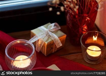 holidays, new year and celebration concept - close up of christmas gift on window sill at home. christmas gift on window sill at home