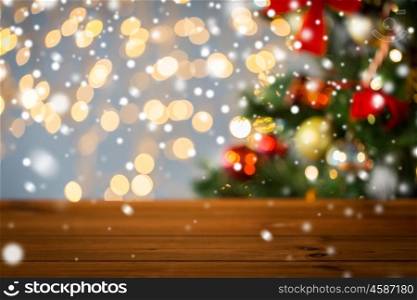 holidays, new year and celebration concept - close up of empty wooden surface or table over christmas tree and lights background