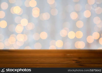 holidays, new year and celebration concept - close up of empty wooden surface or table over christmas golden lights background