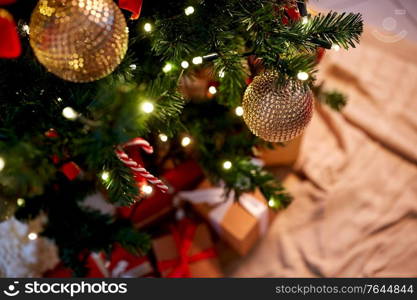 holidays, new year and celebration concept - green artificial christmas tree decorated with toys at home. decorated artificial christmas tree at home