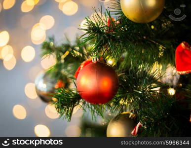 holidays, new year, decor and celebration concept - close up of christmas tree decorated with balls