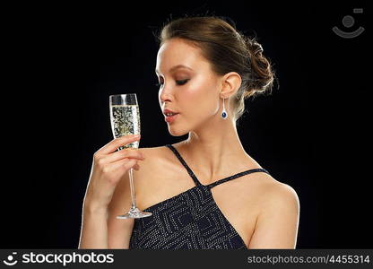 holidays, nightlife, drinks, people and luxury concept - beautiful young asian woman drinking champagne at party over black background and spotlights