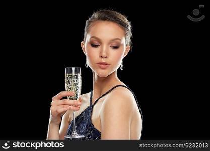 holidays, nightlife, drinks, people and luxury concept - beautiful young asian woman drinking champagne at party over black background and spotlights
