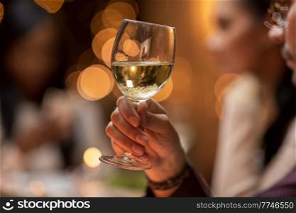 holidays, party and celebration concept - close up of man having christmas dinner at home and drinking white wine. close up of man drinking wine at christmas party